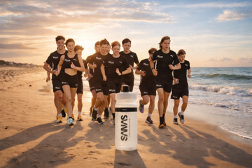 Lopers met drinkfles tijdens een zomertraining op het strand